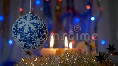 一个大<strong>蓝球</strong>挂在圣诞树上。 新年和圣诞装饰品。 燃烧蜡烛。 燃烧的